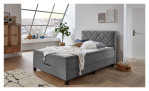 Boxspringbett Josh in einem silberen Bezug in mikrofaser und schwarzen füßen. Auf einem dekorierten Hintergrund.